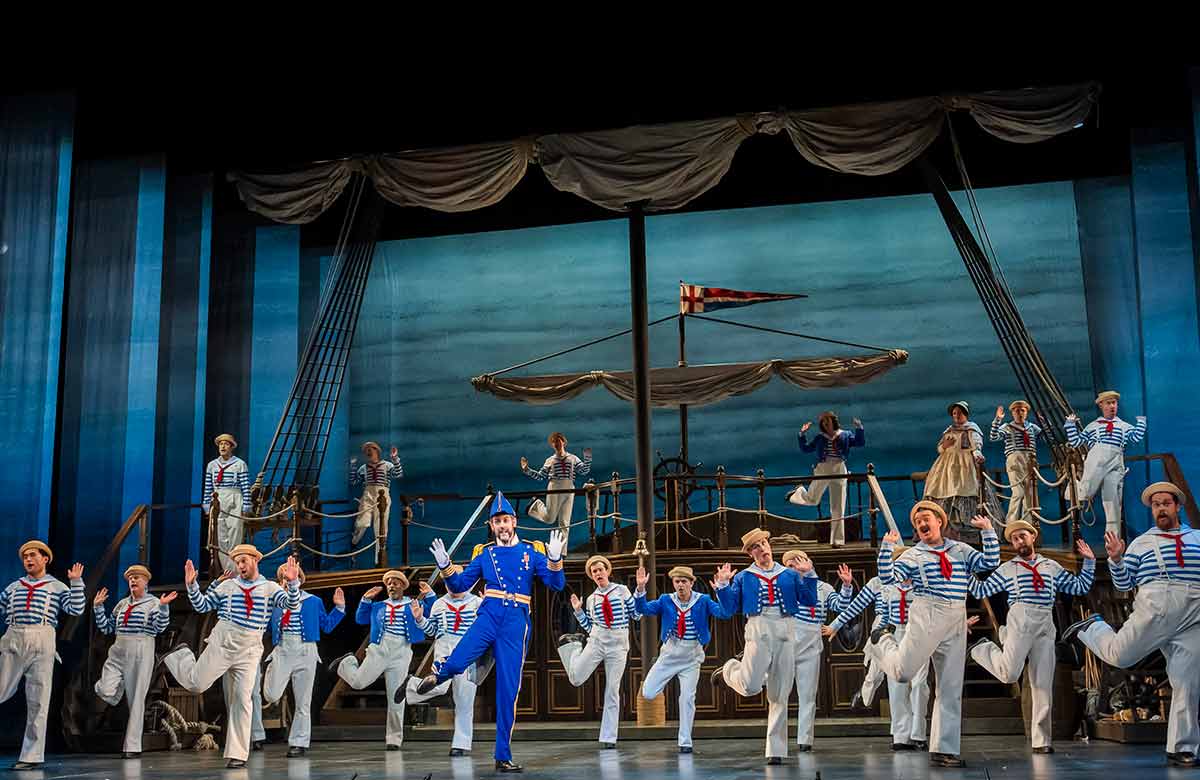 John Savournin (centre) in HMS Pinafore at the London Coliseum. Photo: Tristram Kenton