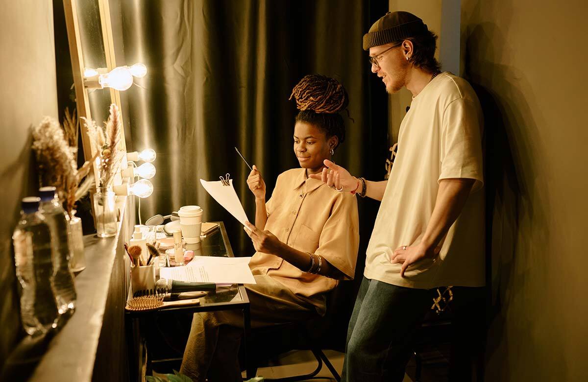Two actors preparing backstage in theatre dressing room. Photo: Shutterstock